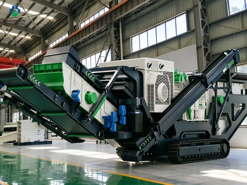 Crawler impact crusher station assembly line in workshop with tracked chassis and impact crusher unit