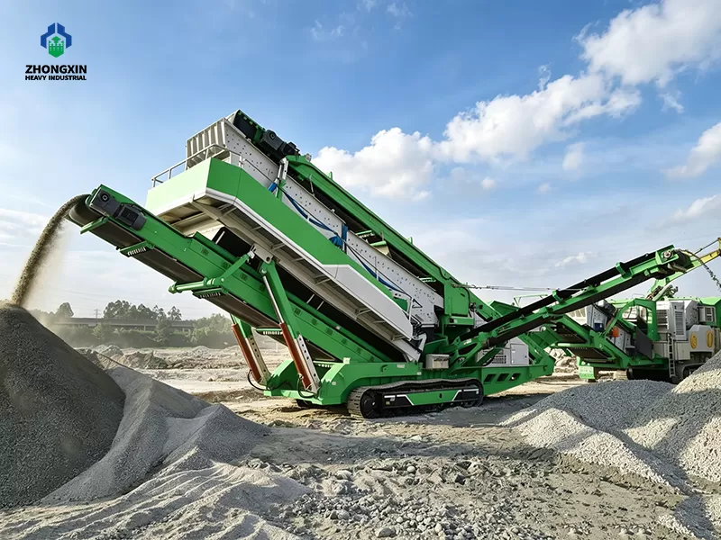 Wide shot of mobile sand crushing machine producing manufactured sand at quarry job site