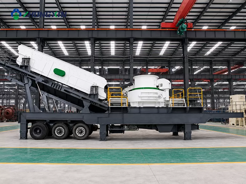 Inside the assembly workshop: workers inspecting the VSI crusher unit of a trailer-mounted mobile aggregate crushing plant.