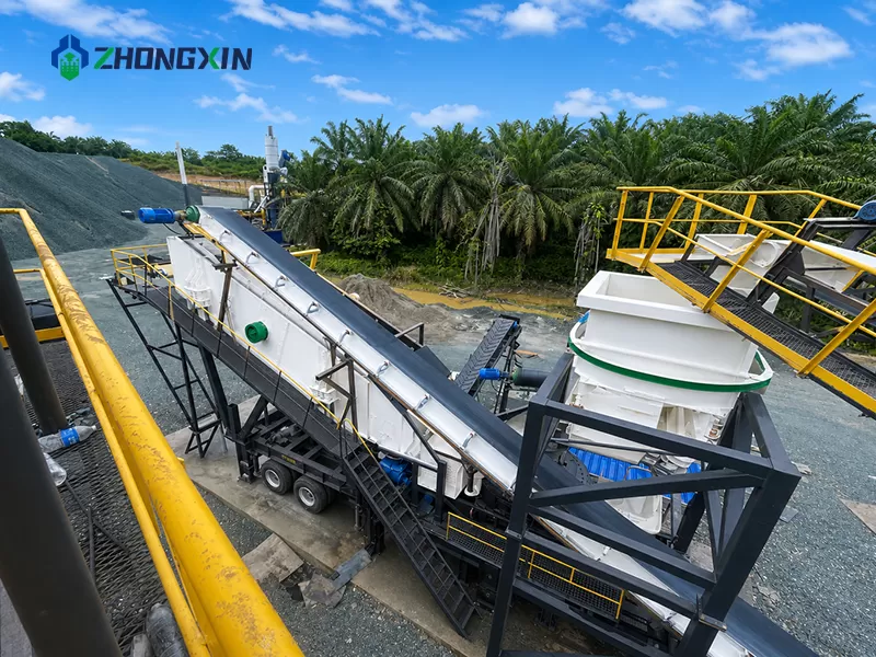 Close-up view of manufactured sand discharging from the conveyor belt of an operating mobile VSI crushing station