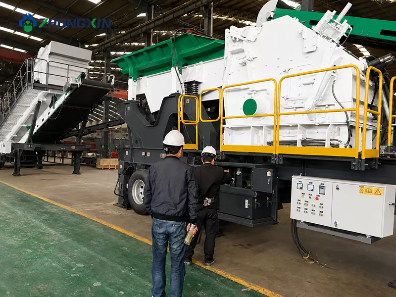 Engineers inspecting the secondary impact crusher module inside the heavy machinery assembly workshop