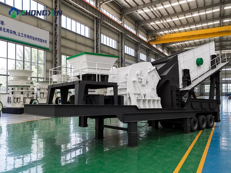 Workers assembling the heavy chassis of a mobile crushing and screening plant in our manufacturing workshop