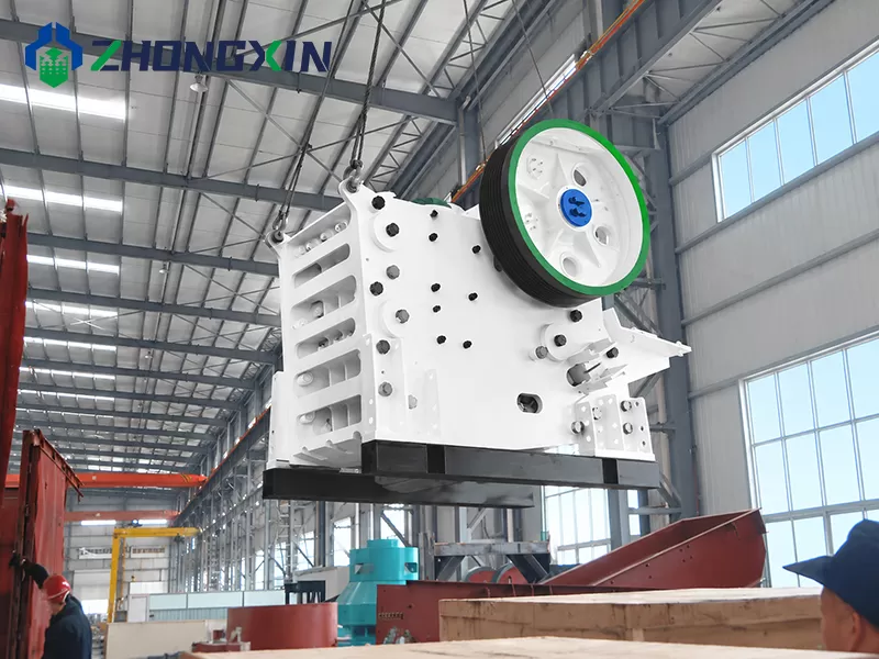 European series jaw crusher body during workshop crane hoisting process.