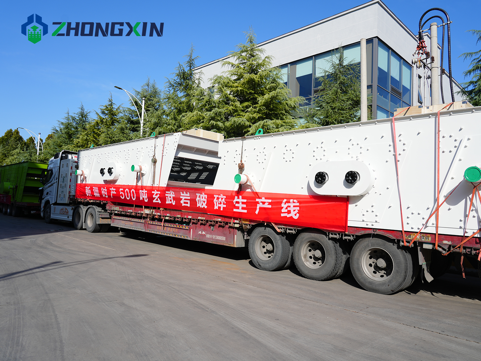 Heavy-duty logistics truck with dispatch banner carrying 2YA3072 vibrating screen for Xinjiang aggregate project.JPG
